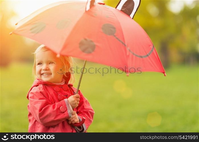 Happy baby with red umbrella