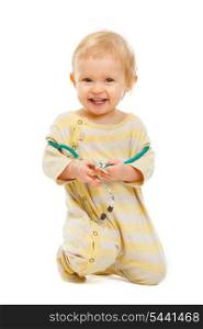 Happy baby with stethoscope sitting on floor isolated on white
