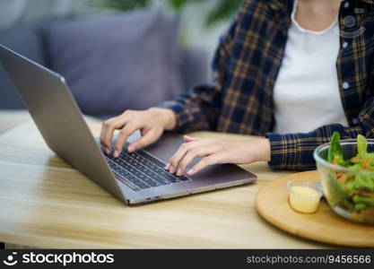 Happy beautiful Asian woman using computer laptop for work online at living room.