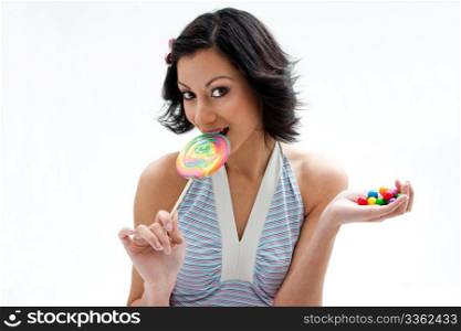 Happy beautiful candy girl with a hand full of colorful bubblegum candy balls licking a lollipop, isolated