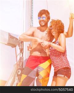 Happy beautiful couple having fun on sailboat, joyful young family enjoying sea traveling, active summer adventure