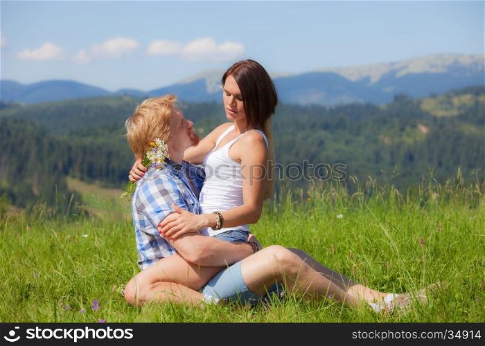 Happy beautiful couple in love on the green grass field