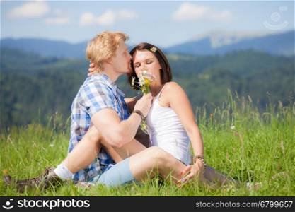 Happy beautiful couple in love on the green grass field