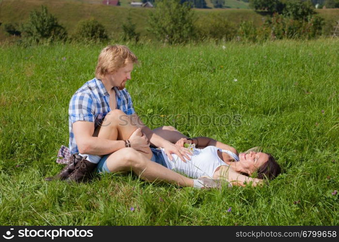 Happy beautiful couple in love on the green grass field