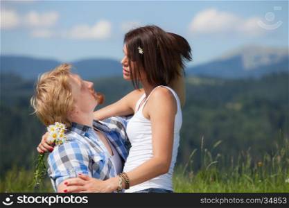 Happy beautiful couple in love on the green grass meadow