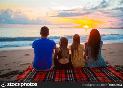 Happy beautiful family at sunset on the beach. Young family on vacation at the evening