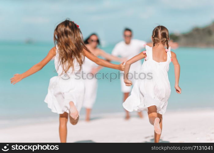 Happy beautiful family on the beach having fun. Photo out of focus. Young family of four on vacation have fun