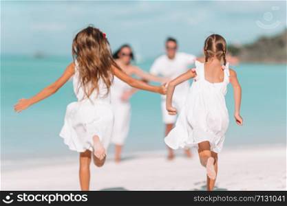 Happy beautiful family on the beach having fun. Photo out of focus. Young family of four on vacation have fun