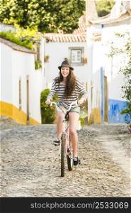 Happy beautiful female tourist riding a bicycle