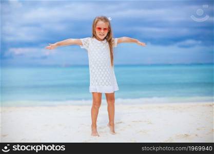 Happy beautiful girl enjoy beach tropical vacation. Adorable little girl at beach on her summer vacation