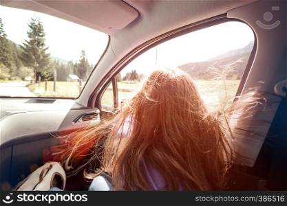Happy beautiful girl traveling in a car across at the mountains Dolomites, Italy. Europe