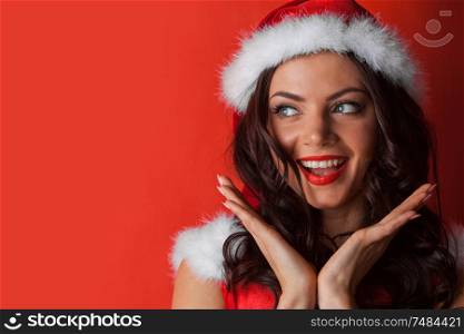 Happy beautiful girl wearing santa hat on red background, Christmas concepts. Girl wearing santa hat