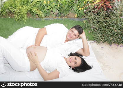 Happy beautiful pregnant woman with his husband outdoors