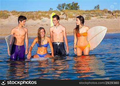 Happy beautiful teen surfers talking enjoying on beach shore smiling