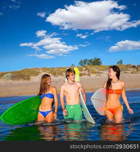 Happy beautiful teen surfers talking on beach shore smiling