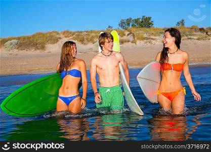 Happy beautiful teen surfers talking on beach shore smiling