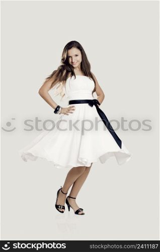 Happy beautiful woman dancing and wearing a wonderful white dress