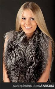 Happy beautiful woman in fur clothings, isolated over dark background