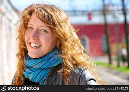 happy beautiful woman is looking at camera at city street