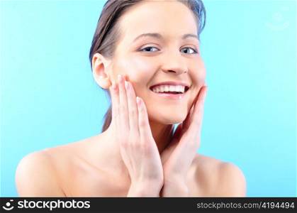 happy beautiful woman is touching her face and looking at camera