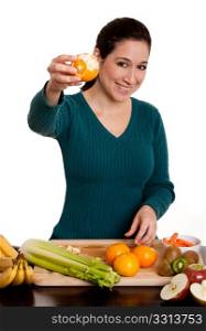 Happy beautiful woman presenting a delicious organic peeled orange fruit full with vitamin C in kitchen, isolated.