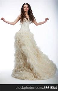 Happy beautiful woman with long curly hair in luxurious wedding dress posing