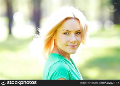 Happy beautiful young woman in park