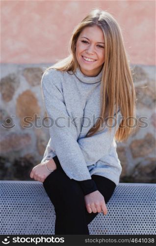 Happy beautiful young woman laughing sitting on the bench