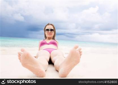 Happy beauty girl lying on the beach