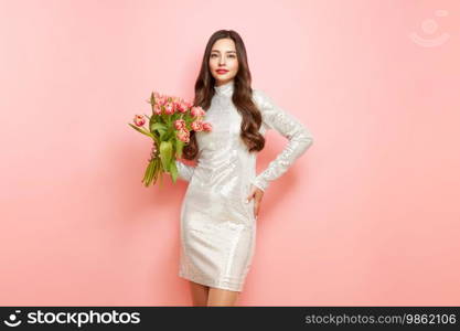 Happy beauty woman with pink tulip bouquet on light pink background. 8th of March celebration