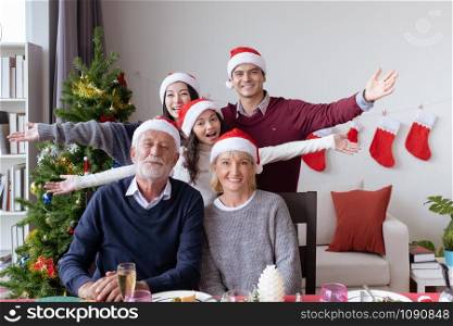 happy big family, meeting and celebrating together at christmas day night in dining room that decorated with christmas tree for christmas festival day, happy family holiday concept