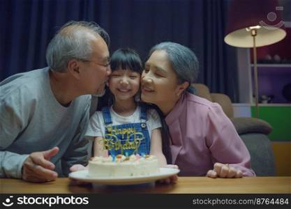Happy Birthday. Asian family grandfather and grandmother kissed granddaughter feeling thankful while celebrating his birthday after giving wonderful cake, senior family party with child at home