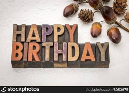 Happy Birthday greeting card - text in vintage letterpress wood type against white Nepalese lokta paper with cone and acorn fall decoration