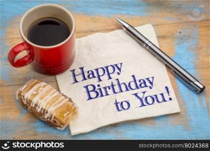 Happy Birthday to you greeting - handwriting on a napkin with a cup of coffee and cookie