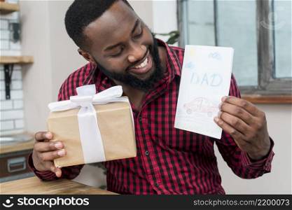happy black man holding greeting card gift