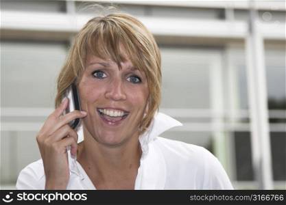 Happy blond businesswoman receiving good news over the phone