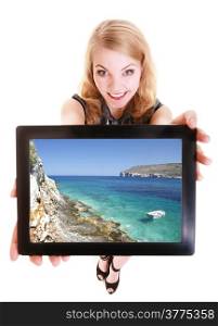 Happy blond businesswoman showing ipad with summer photo of sea landscape. Modern young woman girl holding tablet touchpad and dreaming about vacation. Technology and dream. Isolated. Studio shot.