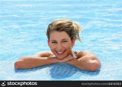 Happy blond girl at a poolside