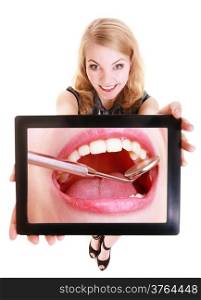 Happy blond girl showing ipad with photo of white female teeth. Modern young woman holding tablet touchpad recommending dental care. Isolated. Technology and health.