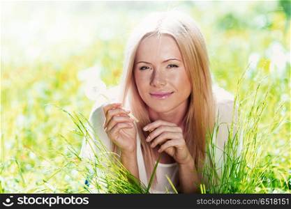 Happy blond Girl with white dandelion in spring park. Girl with dandelion