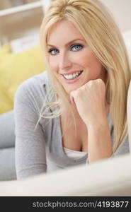 Happy Blond Woman With Blue Eyes Resting on her Hand