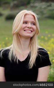 Happy blonde girl outside sunrounded many flower