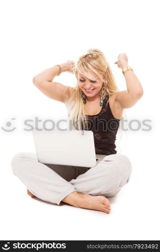 Happy blonde woman sitting on the floor with notebook over white isolated background