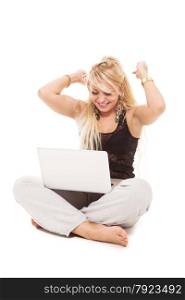 Happy blonde woman sitting on the floor with notebook over white isolated background