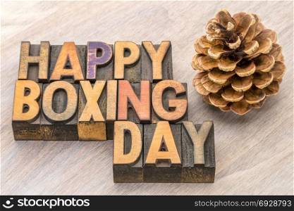 Happy Boxing Day word abstract in vintage letterpress wood type wityh pine cone
