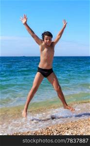 Happy boy jumping on the beach