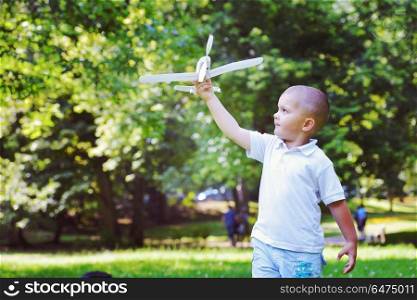 happy boy play and throw airplane in park. boy with airpane