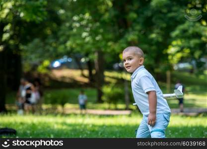 happy boy play and throw airplane toy in park