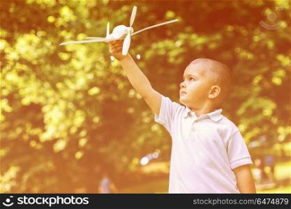 happy boy play and throw airplane toy in park. boy with airpane toy
