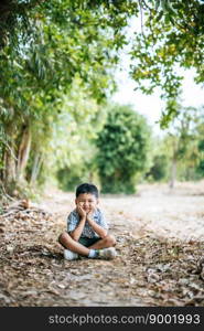 Happy boy sitting and thinking alone in the park